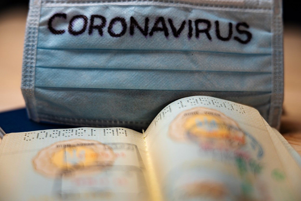 Maska z napisom Coronavirus in osebni dokument.