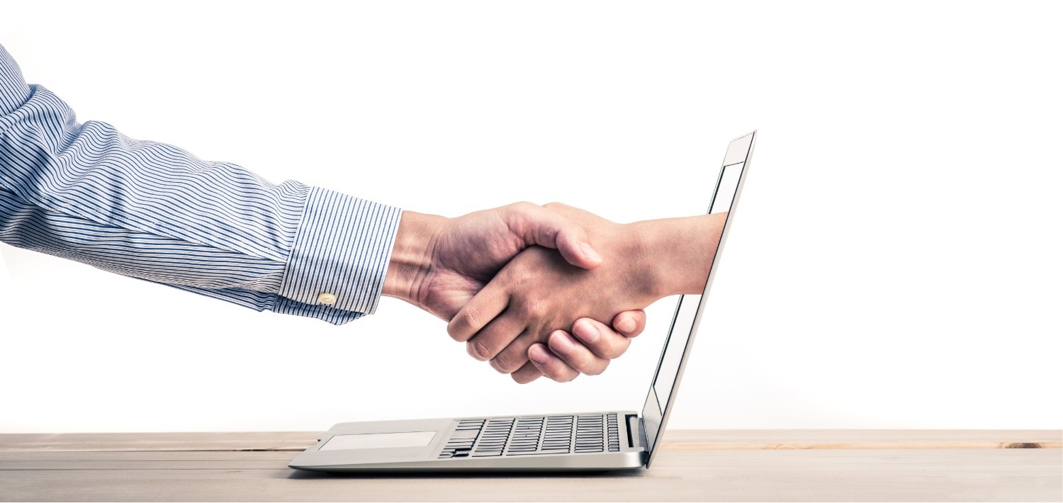 Roka rokuje roko, ki je v prenosnem računalniku.