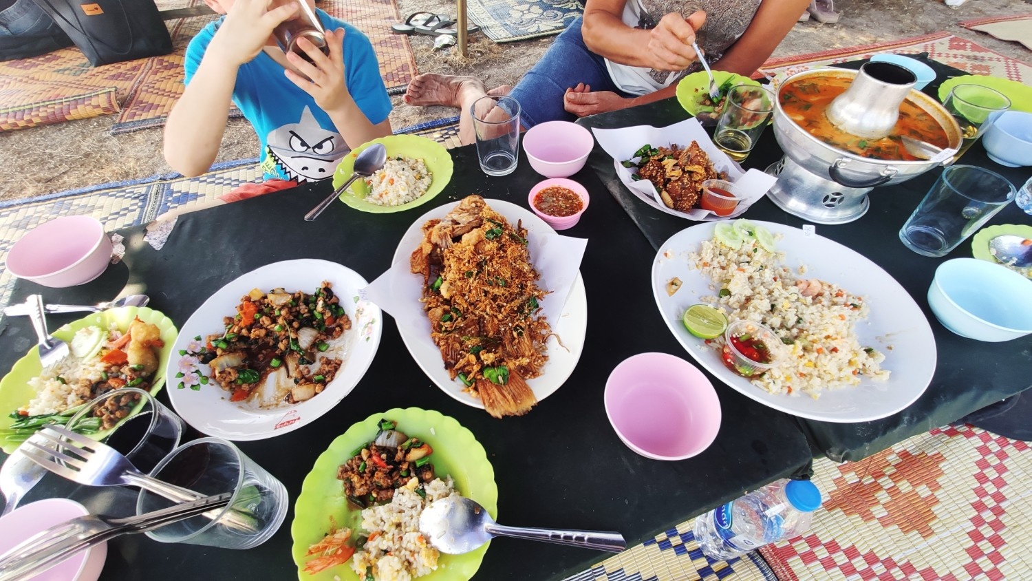 Nizka miza polna različnih kozarcev in krožnikov ter raznolike hrane