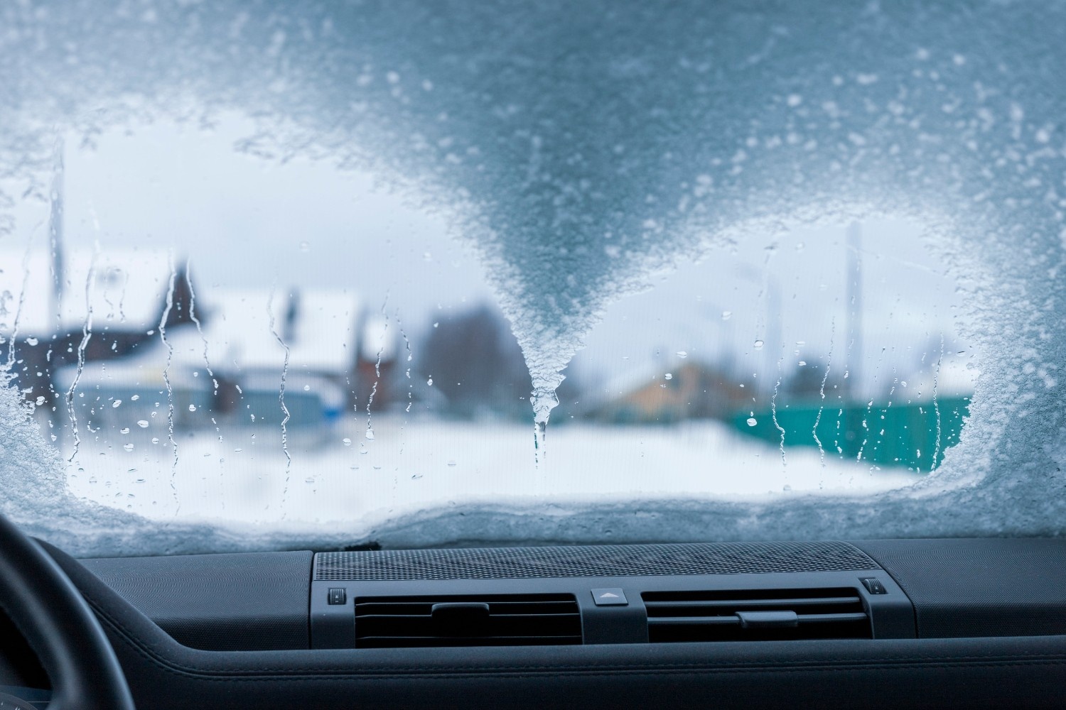 Zaledenelo vetrobransko steklo, ki poslabša vidljivost iz avta.