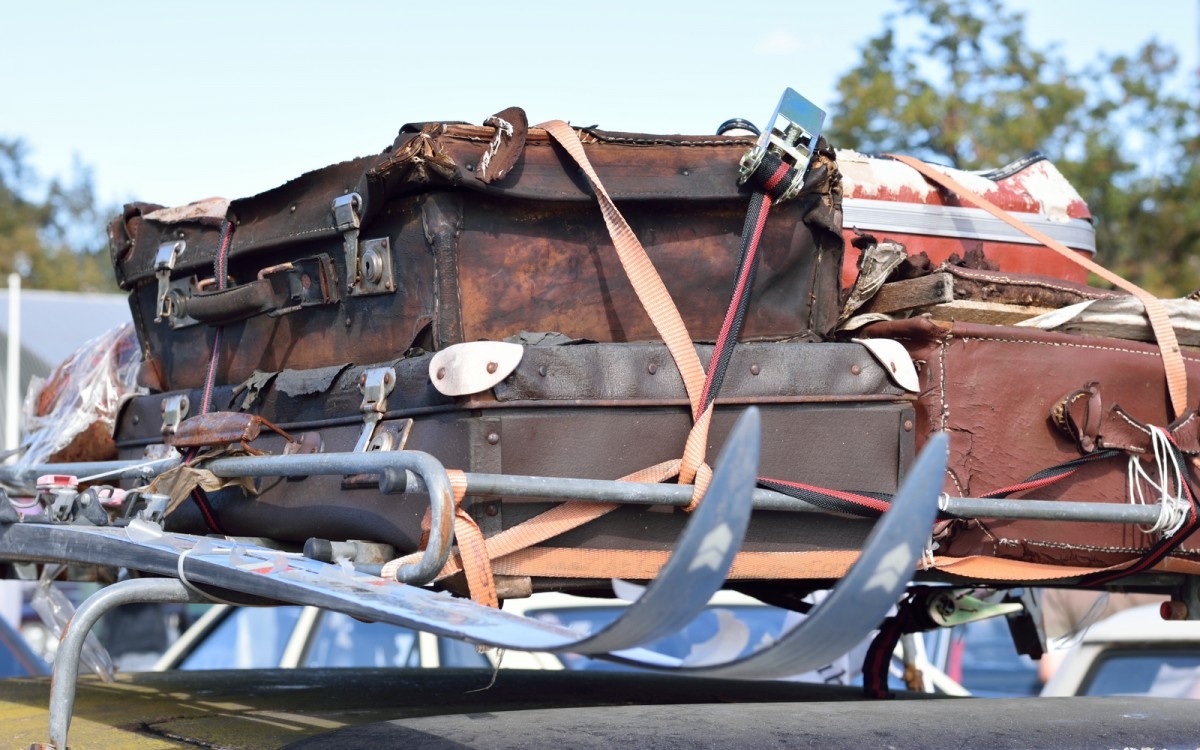 Kup potovalk, kovčkov in smuči na vrhu avta.