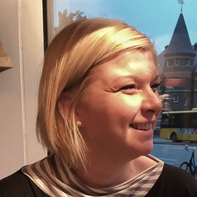 Ženska s kratkimi blond lasmi se smehlja