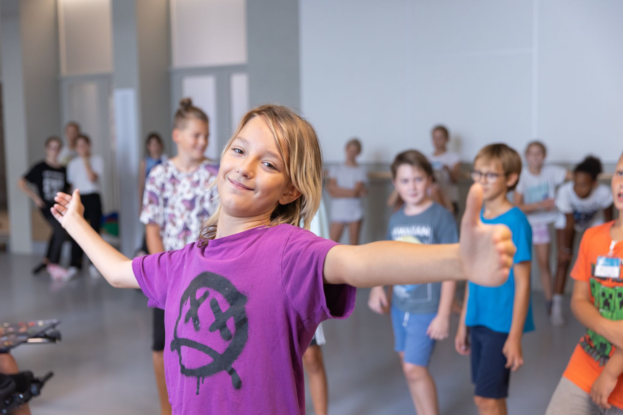 Otroci sredi treninga sodobnega plesa v plesni dvorani.