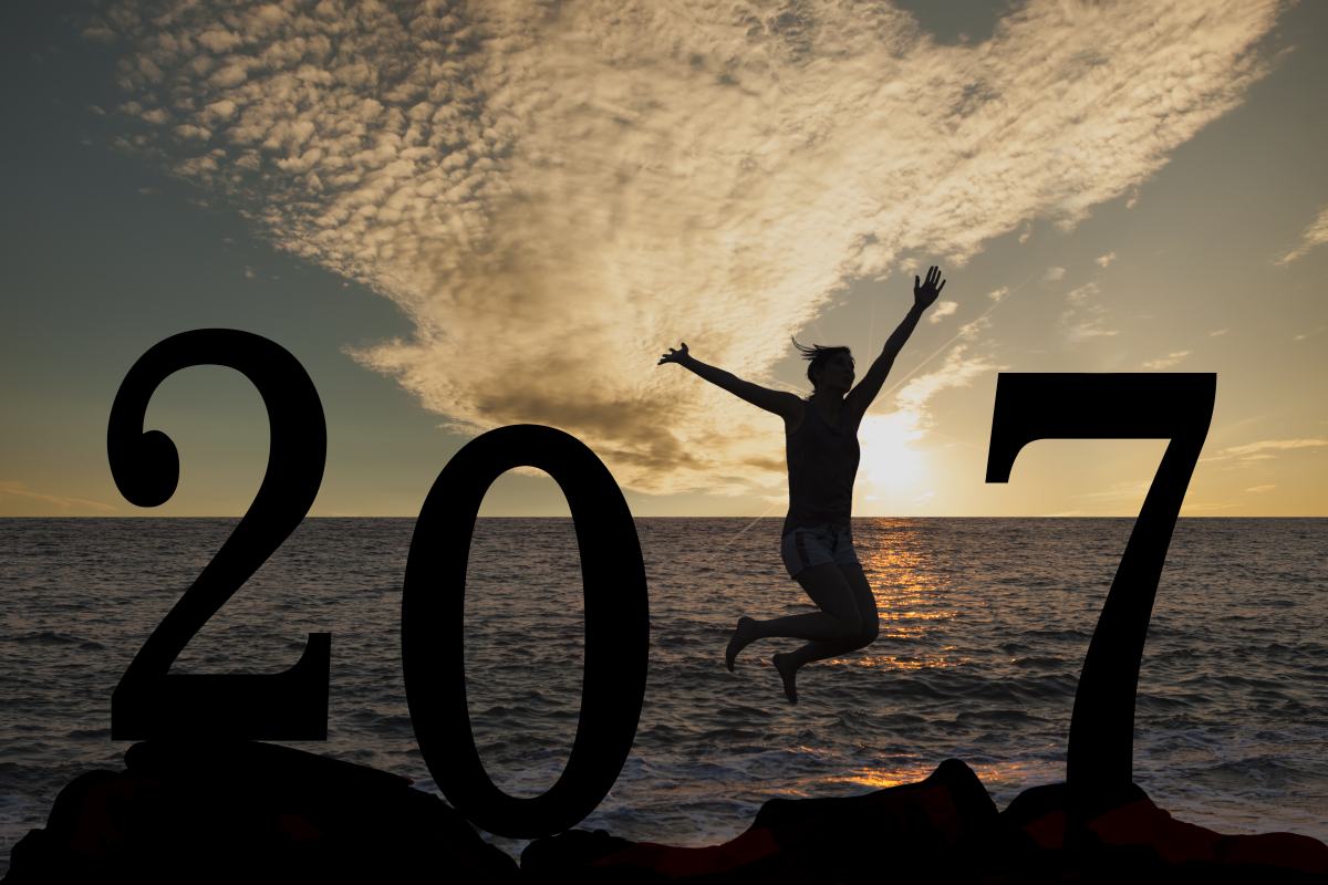 Na plaži senca osebe, ki skače med velikimi številkami, vse skupaj piše 2017.