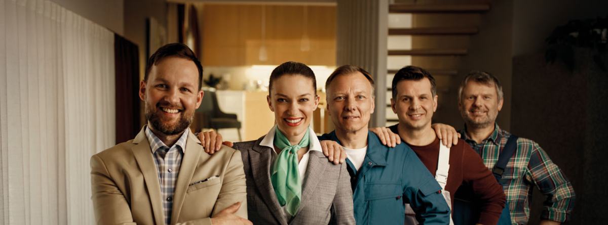 Pet sodelavcem stoji eden zraven drugega v sodelovanju.