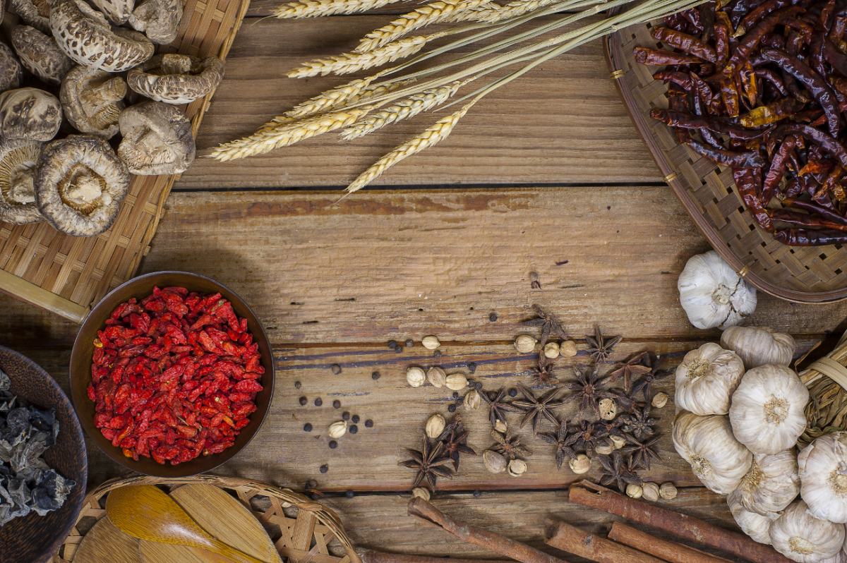 Na leseni mizi so različne začimbe, pisana zelenjava in žitarice.