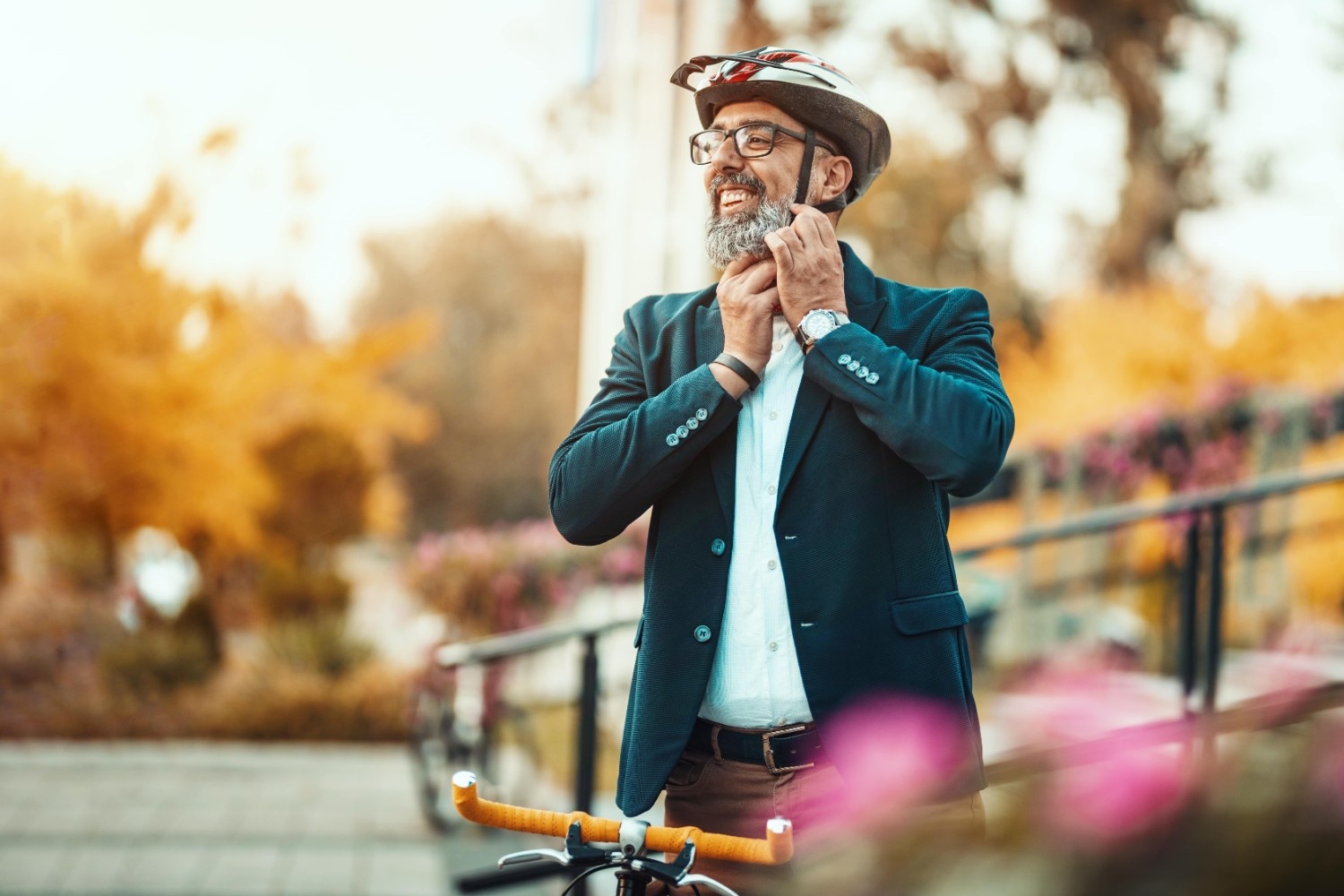 Gospod si veselo namešča čelado na glavo in se odpravlja na vožnjo s kolesom.