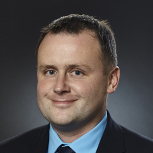 Matevž Čuček oblečen v suknjič in srajco se smehlja proti kameri